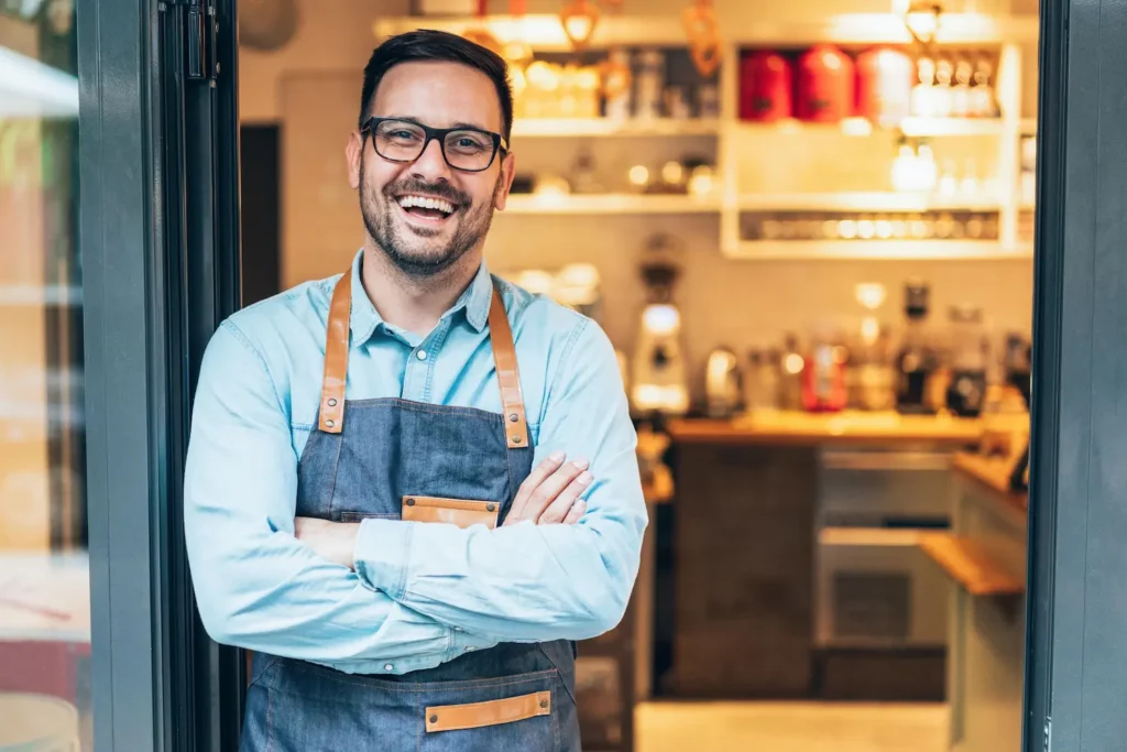 Um Grupo Sorridente De Diversos Empresarios Trabalhando Juntos Em Torno De Uma Mesa De Reuniao Em Um Saguao De Um Complexo De Escritorios - Minha Contabilidade